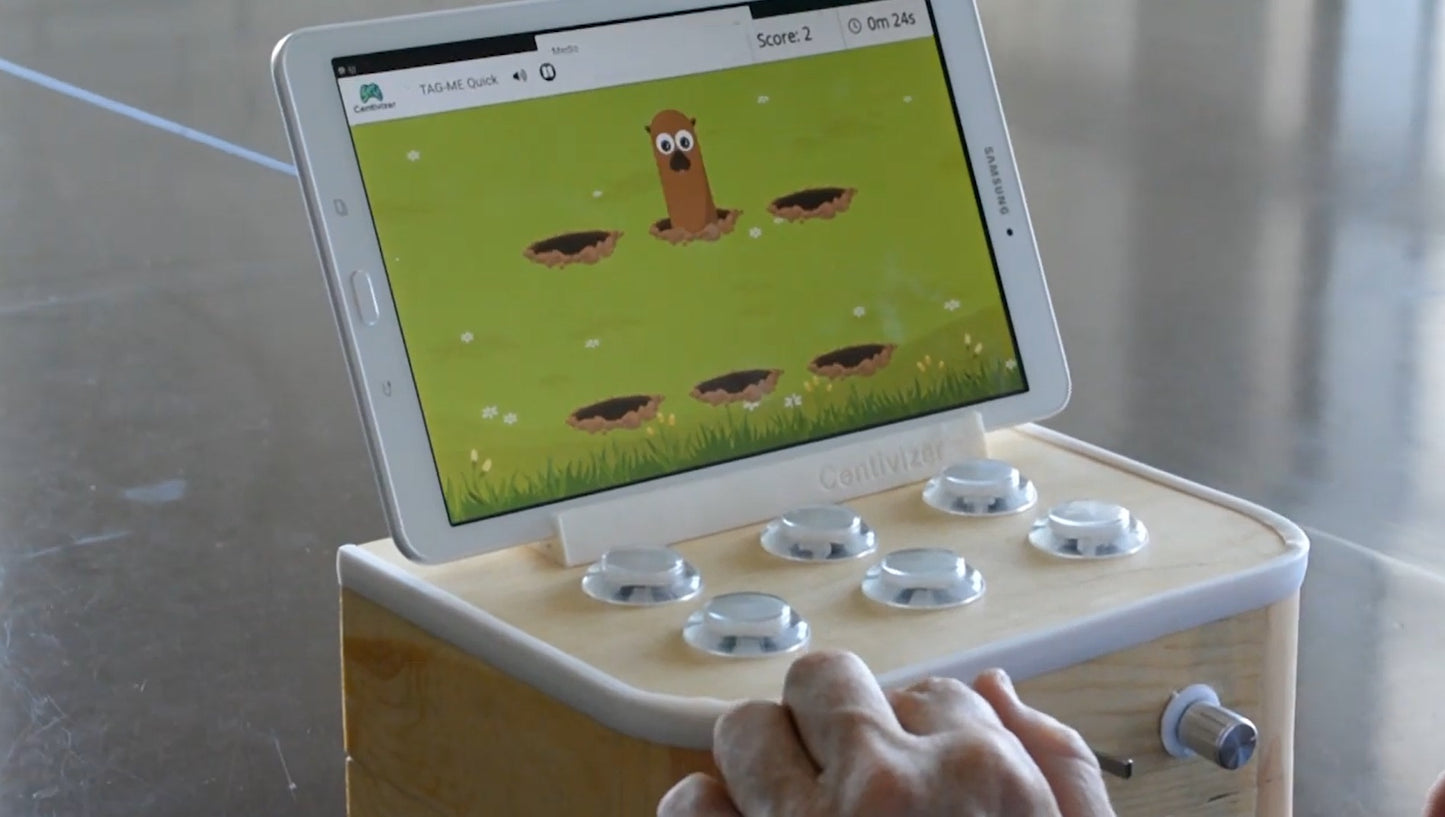 BrainTagger button box with a tablet showing a whack-a-mole game.